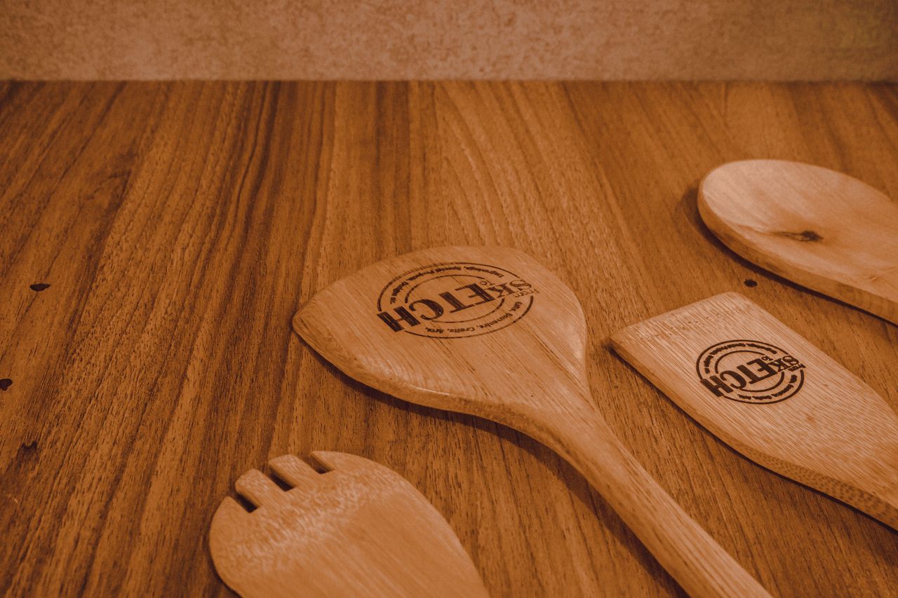 gallery-02 Close-up view of wooden kitchen utensils resting on a rustic wooden surface, ideal for culinary-themed content.